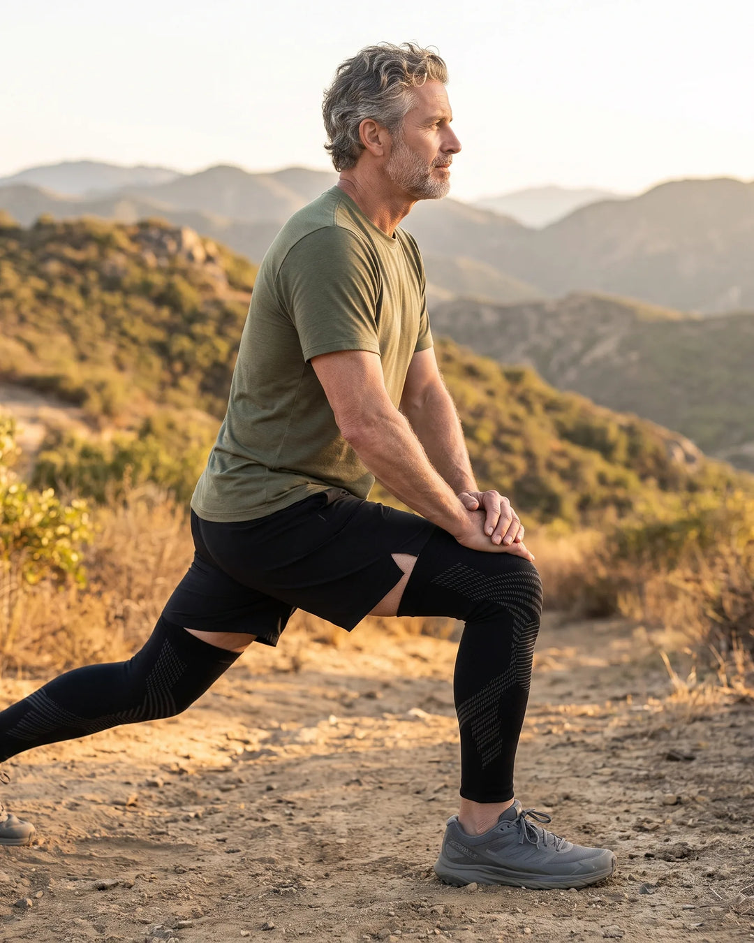 Man stretching on a mountain trail wearing TORVELL full-leg knee compression sleeves